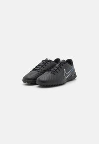 Sorte fodboldstøvler med struktureret overdel, der har et buet design, snører og et sølvfarvet Nike-logo med blå accent.