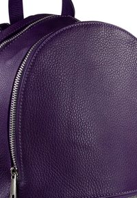 Paarse leren rugzak met een afgeronde vorm, gestructureerd oppervlak, zilveren rits en dubbele schouderbanden. Close-up toont het materiaal.