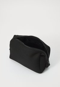 Black zippered pouch made of durable fabric. Features a smooth exterior, rounded shape, and an interior pocket for organization.