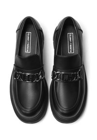 Mocassini in pelle nera caratterizzati da una texture liscia, un dettaglio a catena chunky sulla parte superiore e un design con punta rotonda.