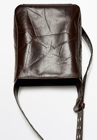 Brown leather shoulder bag with a creased texture, square shape, a long adjustable strap, and silver hardware accents.