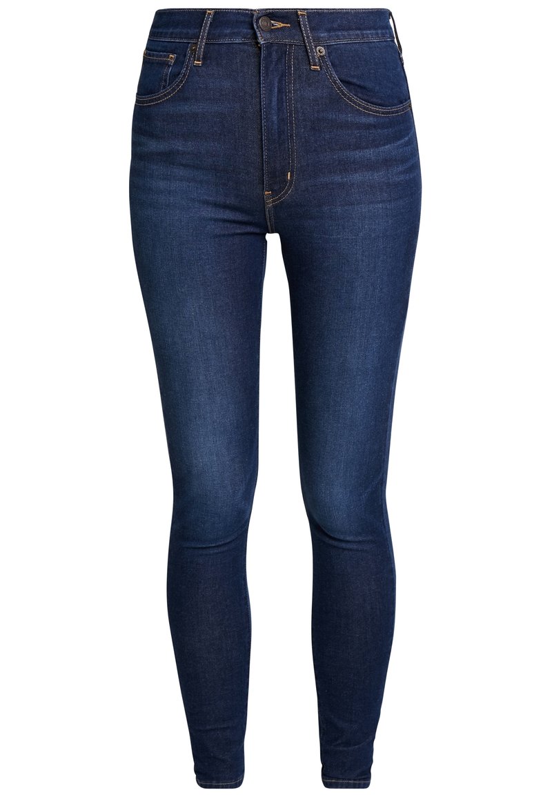 Jeans skinny azul oscuro de denim, con cintura alta, diseño de cinco bolsillos, herrajes en tono dorado y un suave desgaste en toda la prenda.