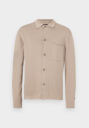 Cardigan tricotat bej, cu guler, închidere cu nasturi, un singur buzunar pe piept și manșete cu nervuri. Textură netedă și design clasic.