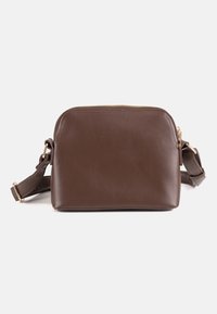 Bolso bandolera de cuero marrón con correa ajustable y cierre de cremallera dorada, mostrado sobre un fondo blanco liso.
