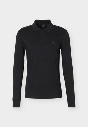 Zwart poloshirt met lange mouwen, twee knopen, klassieke kraag en een subtiele logopatch op de linkerborst tegen een lichte achtergrond.