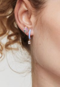 Kolorowe kolczyki w kształcie cukierka z różowym wzorem babeczki, niebieską obręczą i przezroczystym kryształowym akcentem. Wykonane z metalu i emalii.