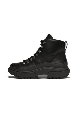 Bottines en cuir noir avec une semelle épaisse, œillets métalliques et finition texturée. Comprend une languette et des lacets épais pour un maintien sécurisé.