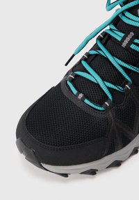 Scarpa sportiva nera in rete con lacci turchesi e suola grigia su sfondo bianco, mostrata in primo piano dalla zona della punta.