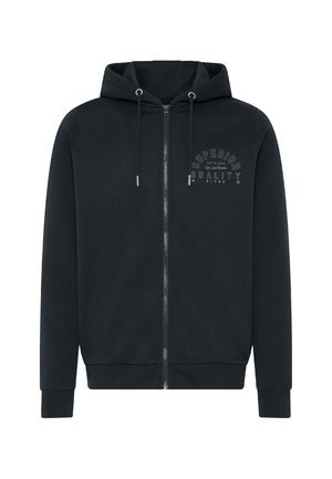 Svart hettejakke med glidelås laget av mykt stoff. Har en hette med snor og et trykk på forsiden som sier "SUPERIOR QUALITY." Ribbet mansjetter og kant.