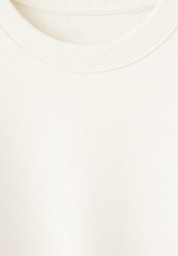 Sudadera color crema con cuello redondo acanalado, textura de tela suave y un diseño simple y minimalista sin patrones ni adornos.