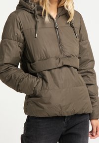 Giacca a vento imbottita di colore verde oliva, con cappuccio, chiusura con zip davanti e stringhe regolabili. Materiale testurizzato e imbottito con vita stretta.