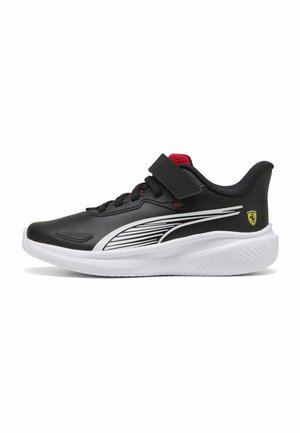 Sort-hvid Puma-sneaker med rød indvendig, snørebånd og remlukning, med Ferrari-logo på hælen og strømlinet design på siden.