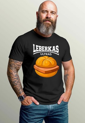 Schwarzes T-Shirt mit dem Aufdruck "LEBERKAS ULTRAS" in Weiß, darunter eine Grafik von einem orangefarbenen, runden Gebäck. Lässiges Design mit kurzen Ärmeln.