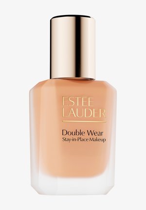 Fond de teint Estee Lauder Double Wear dans un flacon en verre transparent avec un capuchon métallique doré. Il contient un liquide couleur pêche avec une finition mate.
