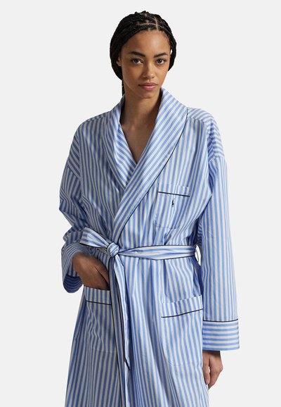 Μπλε και λευκή ριγωτή ρόμπα μπάνιου με ζώνη στη μέση, μακριά μανίκια, δύο μπροστινές τσέπες και μαύρη επένδυση στις άκρες.