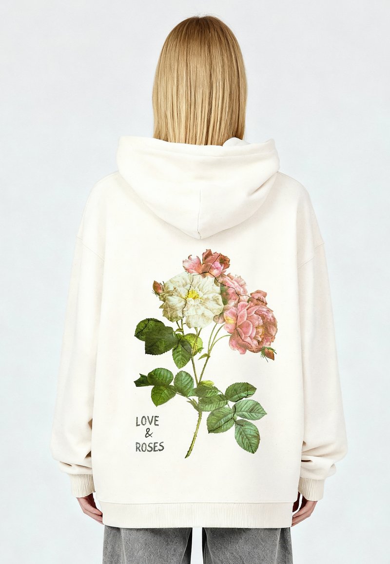 Sudadera con capucha color crema con un gráfico floral de rosas rosas y blancas con hojas verdes, texto "LOVE & ROSAS" en fuente oscura en la parte inferior.