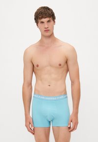 Boxer briefs de color azul claro con una textura suave, que cuentan con una cinturilla gris con "KARL LAGERFELD" impreso en letras negritas.