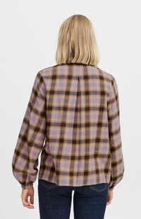 Blouse à manches longues, en vichy dans des tons violets, bruns et jaunes. Présente une coupe décontractée, des poignets élastiques et un détail de pli au dos.