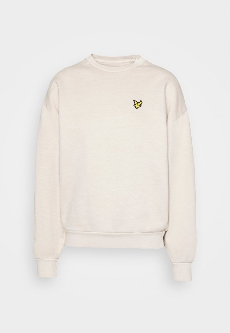 Sweat-shirt à manches longues couleur crème avec un petit logo d'oiseau jaune sur le côté gauche de la poitrine, présentant des poignets et un ourlet côtelés.