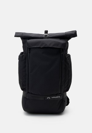 Sac à dos noir à rabat avec un design texturé, plusieurs poches zippées, des bretelles réglables et un logo sur le bas du devant.