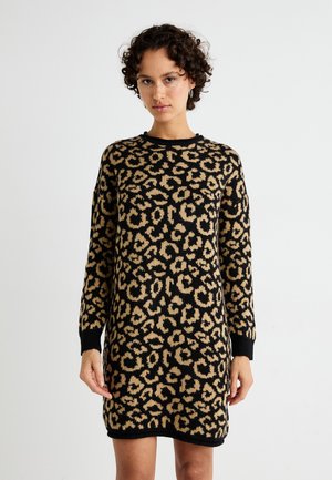 Strikkjede med leopardmønster i sort og tan. Lange ærmer, rund halsudskæring og rib-strikkede manchetter og kant. Blød tekstur.