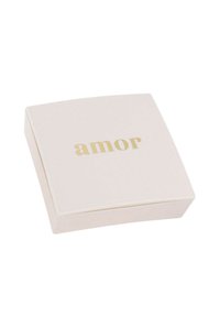 Caja cuadrada de color rosa pálido con una textura suave, que presenta la palabra "amor" en letras doradas en la parte superior. Bordes sutilmente curvados.