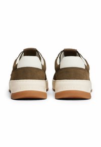 Brązowe zamszowe sneakersy z białą skórą, o teksturowanym wykończeniu, gumowych podeszwach i pętelce z tyłu; z logo "TOMMY JEANS" na pięcie.