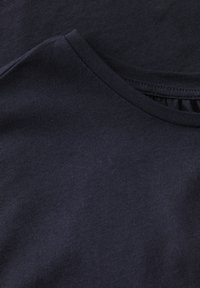 Camiseta de manga corta azul marino con escote redondo. Tejido suave y elástico con una sutil textura acanalada en el cuello.