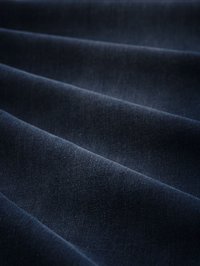Tela de color azul oscuro con una textura suave, que presenta caídas suaves y un sutil brillo, exhibiendo un color sólido sin patrones ni acentos.