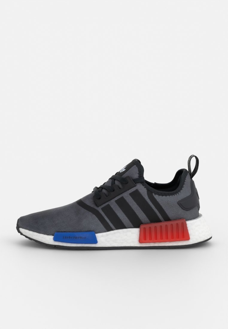 Sportschuhe mit einem grauen Textilobermaterial, schwarzen Streifen, blauen und roten Akzenten, leichtem Design und einer weißen gepolsterten Sohle.