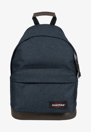 Granatowy plecak z tkaniny z główną komorą zapinaną na zamek, przednią kieszenią, brązowym skórzanym dnem i czarną łatą z logo Eastpak.