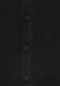 Nahaufnahme eines schwarzen Strickstoffs mit drei bedeckten, runden Knöpfen in einer vertikalen Reihe auf einer gerippten Blende.