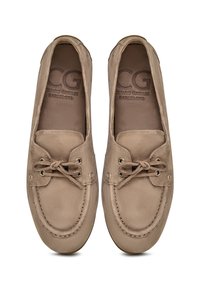 Beige suede loafers med rund tå, syede detaljer, metaløjer og en snørebåndsdetalje på fronten. Indvendig logo præget.
