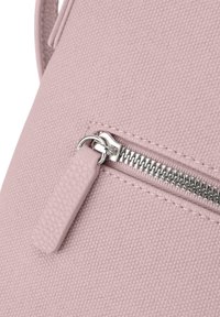 Rosa Handtasche aus Kunstleder mit strukturiertem Oberflächen, ausgestattet mit einem silbernen Reißverschluss und einem Stoff-Reißverschlussanhänger. Kompakte Form, schlichtes Design.