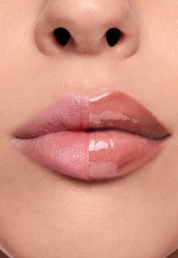 Porównanie ust: lewa strona pokazuje matowy, delikatny róż; prawa strona prezentuje błyszczący, naturalny róż. Obie strony są gładkie z subtelnymi różnicami w teksturze.