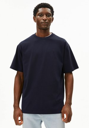 Navy blue cotton t-shirt with a crew neck, short sleeves, and a small logo detail on the chest. Soft texture and relaxed fit.