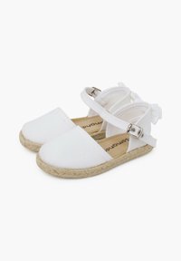 Balti kanvos espadrilės stiliaus sandalai su šiaudų padu, reguliuojama kulkšnies juosta ir maža kaspinu gale. Lygus paviršius ir plokščias dizainas.