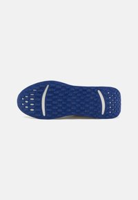 Suela de zapato azul con patrones de tracción rectangulares y ovalados, con dos acentos curvados blancos cerca del talón y las áreas de la bola.