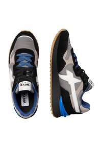 Un paio di sneakers grigie, nere e beige con dettagli e lacci blu, logo a stella bianca e suole in gomma, mostrate in vista dall'alto e di lato su sfondo bianco.