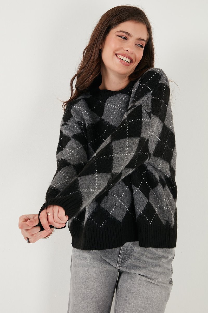 Maglione a scacchi grigio e nero con orlo e polsini a costine, caratterizzato da una consistenza morbida e un motivo a rombi. Vestibilità casual con maniche lunghe.