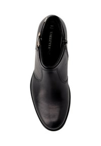 Stivale alla caviglia in pelle nera con texture liscia, punta rotonda e zip laterale. Design minimalista con dettagli di cucitura discreti.