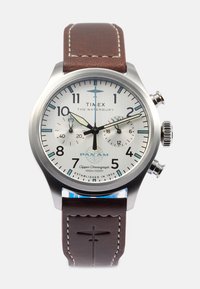 Relógio cronógrafo Timex Waterbury com caixa em aço inoxidável, mostrador branco, detalhes azuis, pulseira de couro castanho e superfície texturizada.