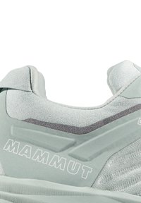 Mintgrön klättersko med texturerad textilovandel, framträdande logotyp, släta detaljer och en vadderad krage för komfort och stöd.