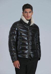 Black puffer jacket with a shiny texture, zip closure, large collar lined with shearling, and two front zip pockets.