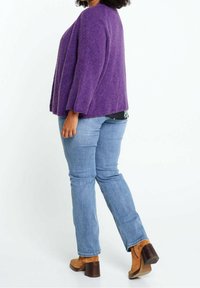 Maglione viola con trama, dalla vestibilità rilassata, con maniche a tre quarti. Abbinato a jeans azzurri chiari e stivaletti con tacco marroni.