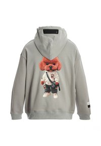Sudadera gris con un gráfico de perro de dibujos animados en la parte posterior, que presenta a un perro de peluche rojo con sudadera y pantalones, con zapatos blancos y un bolso de hombro.