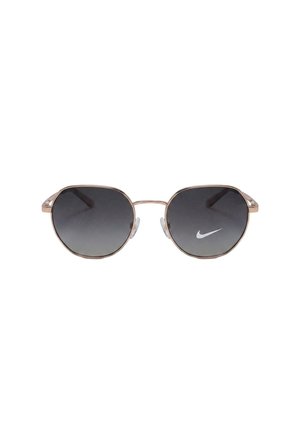 Occhiali da sole con lenti rotonde nere sfumate e sottile montatura in metallo dorato, con logo Nike bianco sulla lente destra.