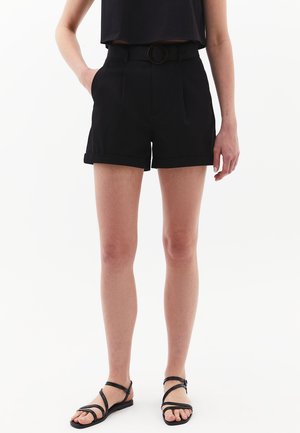 Shorts noirs avec une taille ajustée et une ceinture dotée d'une boucle ronde, poches latérales et ourlets retroussés. Le matériau semble lisse et structuré.