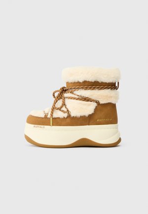 Brown suede ankle boot with cream faux fur trim, textured upper, contrasting brown laces, and thick white platform sole with a tan bottom.