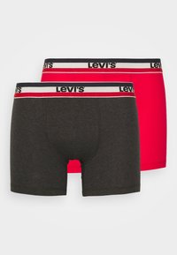 Fekete és piros boxer alsó harisnyák, puha anyagból készült, elasztikus derékkal, fehér és piros Levi's logóval. Egyenes szabású és varrás nélküli kialakítás.